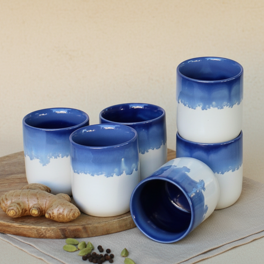 Set of blue and white ceramic cups on a wooden board with spices and ginger.
