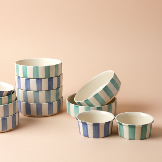 Set of striped ceramic bowls on a beige background