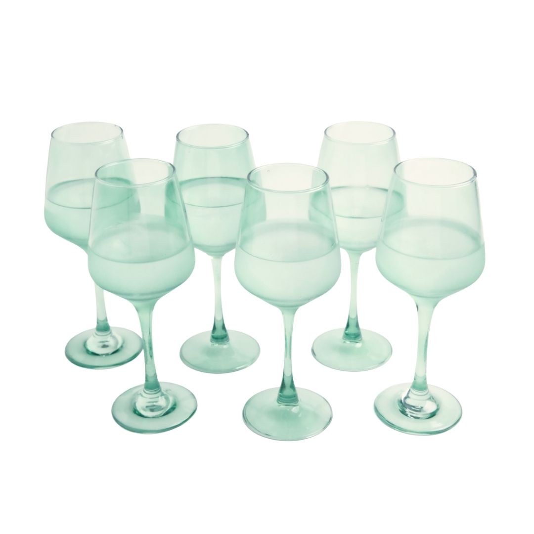 Set of six light green wine glasses on a white background