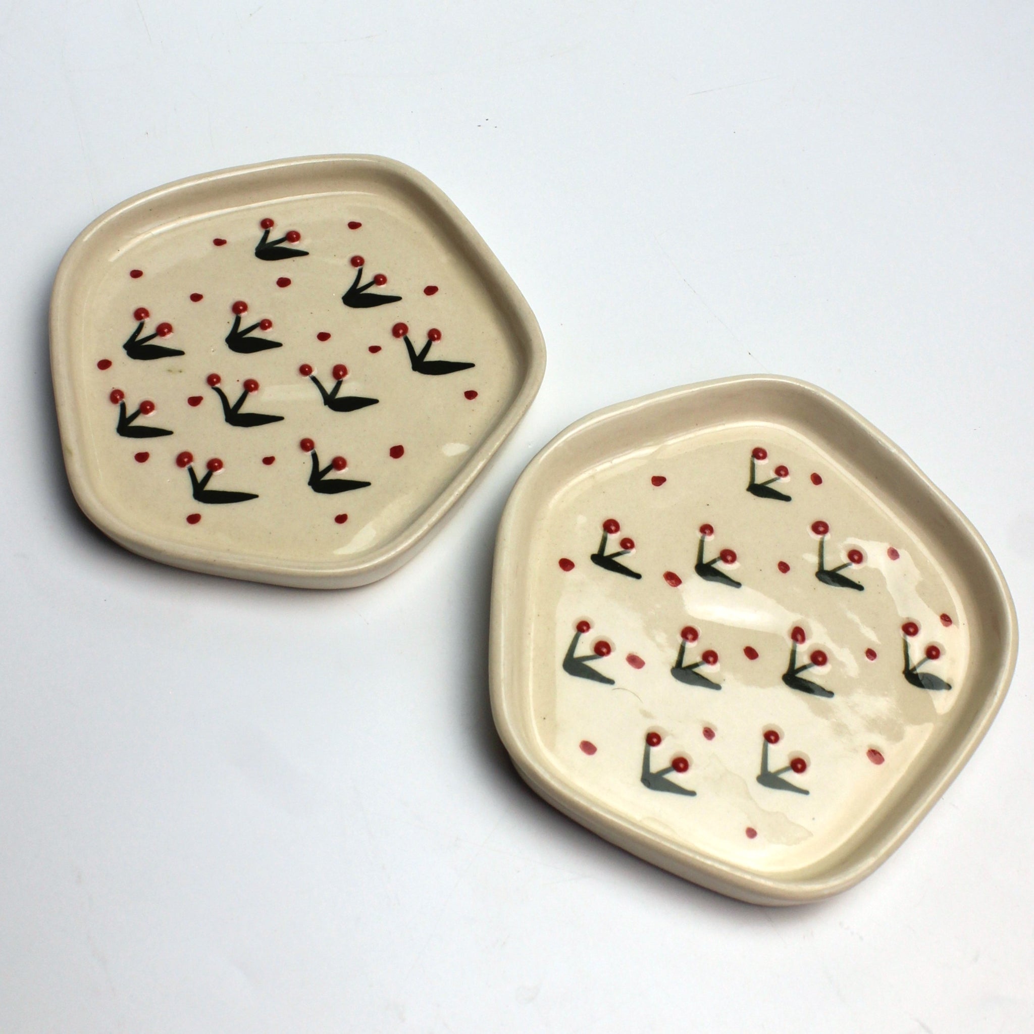 Two ceramic plates with decorative patterns on a light gray background
