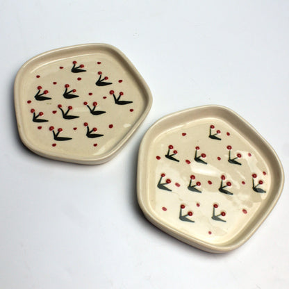 Two ceramic plates with decorative patterns on a light gray background