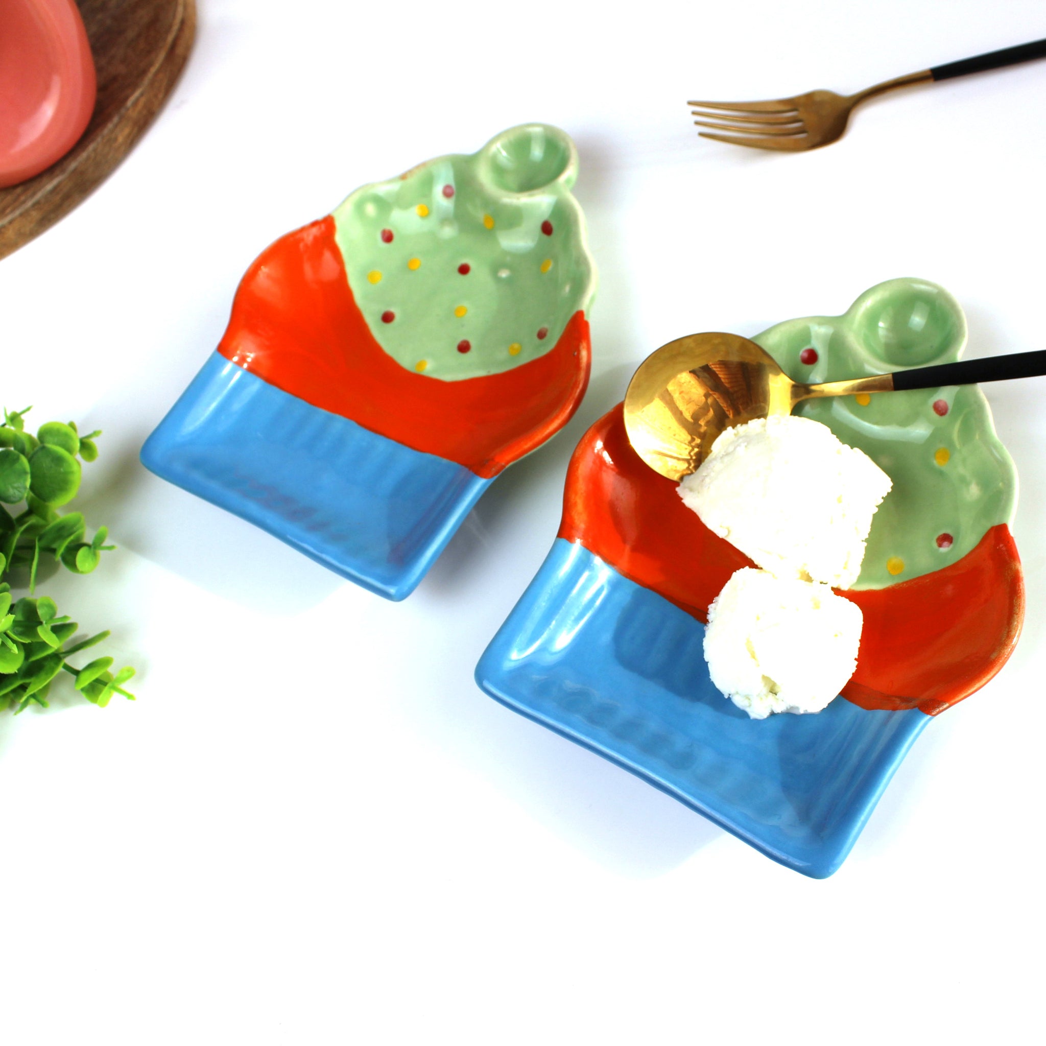 Two colorful ceramic plates with ice cream and a spoon on a white background