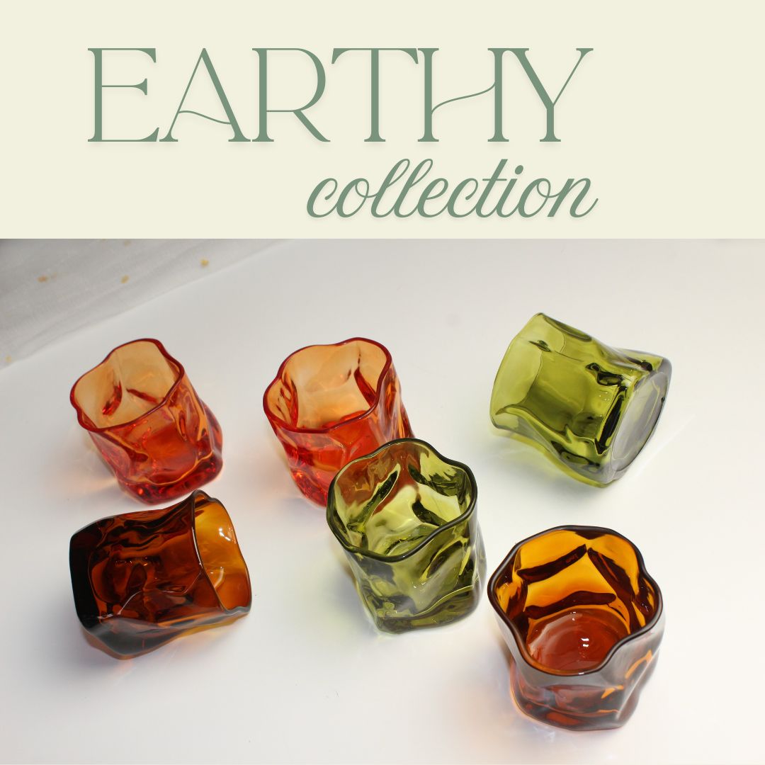 Set of colorful glass votive holders with 'Earthy collection' text above on a light background